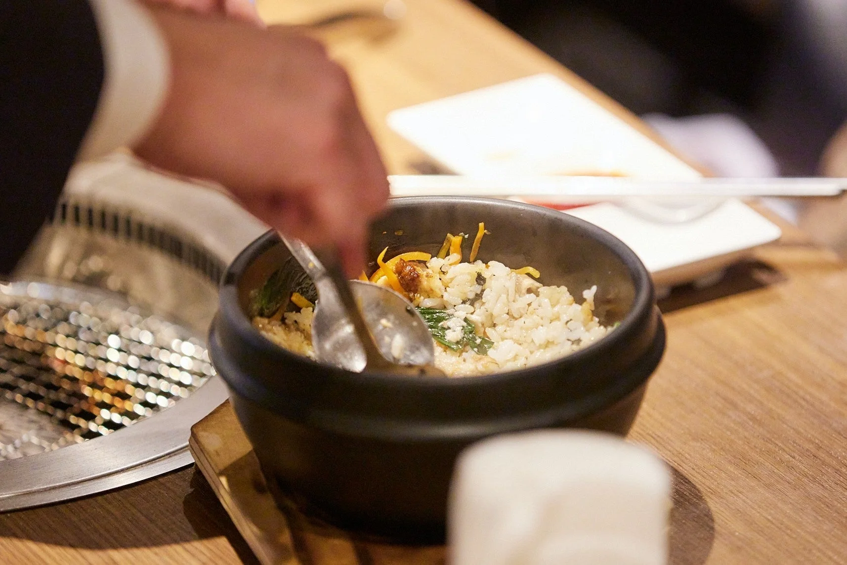 メディア試食会で提供された「うなぎの石焼ビビンバ」を混ぜる様子