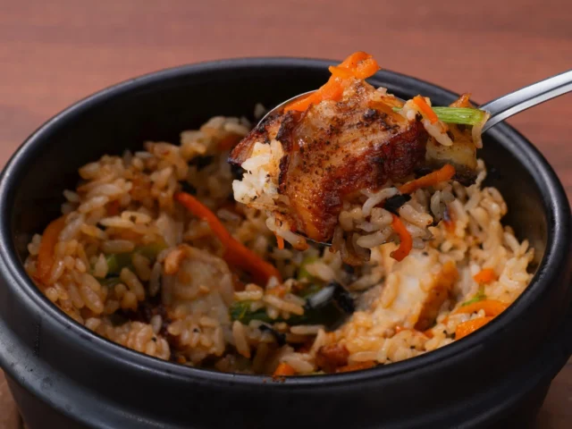 炭火で香ばしく焼き上げたうなぎの石焼ビビンバをスプーンで掬う