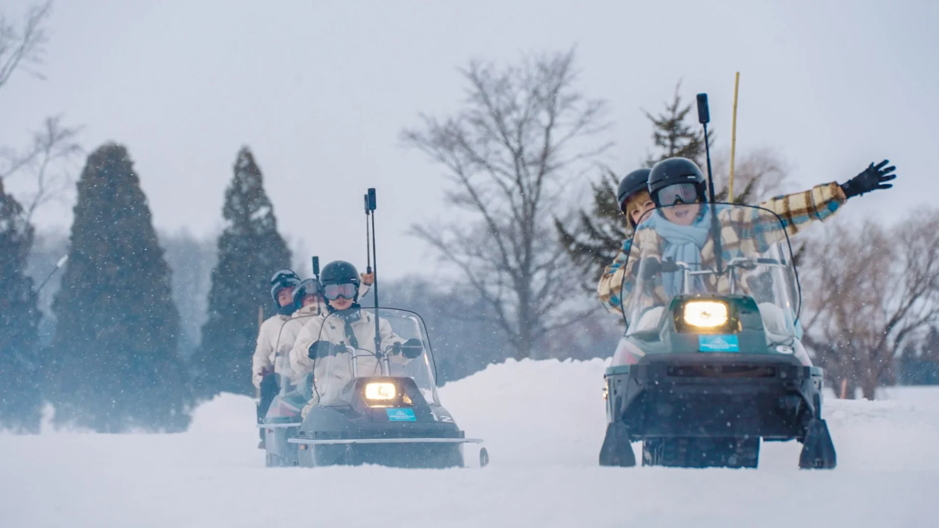 雪原でInsta360カメラを手にスノーモービルに乗る人々