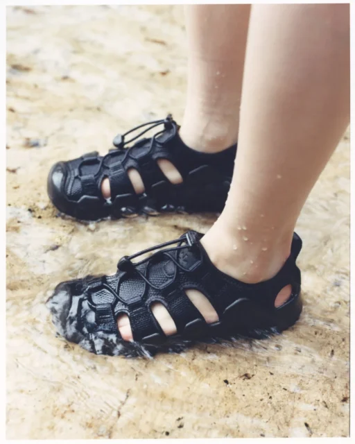 水辺でHYPERPORT H2オールブラックサンダルを履く足元