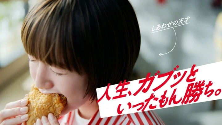 チキンにかぶりつく佐藤栞里さんと「人生、ガブッといったもん勝ち。」の文字