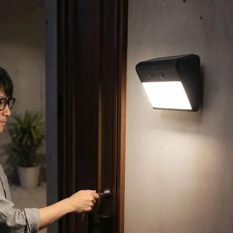 玄関に設置されたソーラー屋外カメラ『400-SSA013』と人物