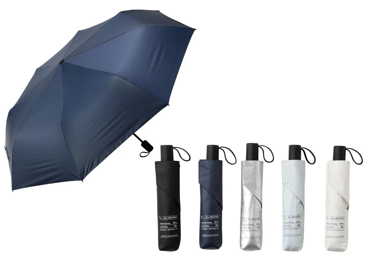 ネイビーの開いた折りたたみ傘と、たたんだ状態の様々な色の傘が並べられている。