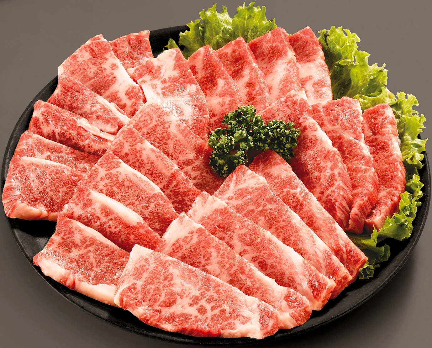 鮮やかな赤身とサシが入った国産黒毛和牛のスライス肉が皿に盛り付けられている。