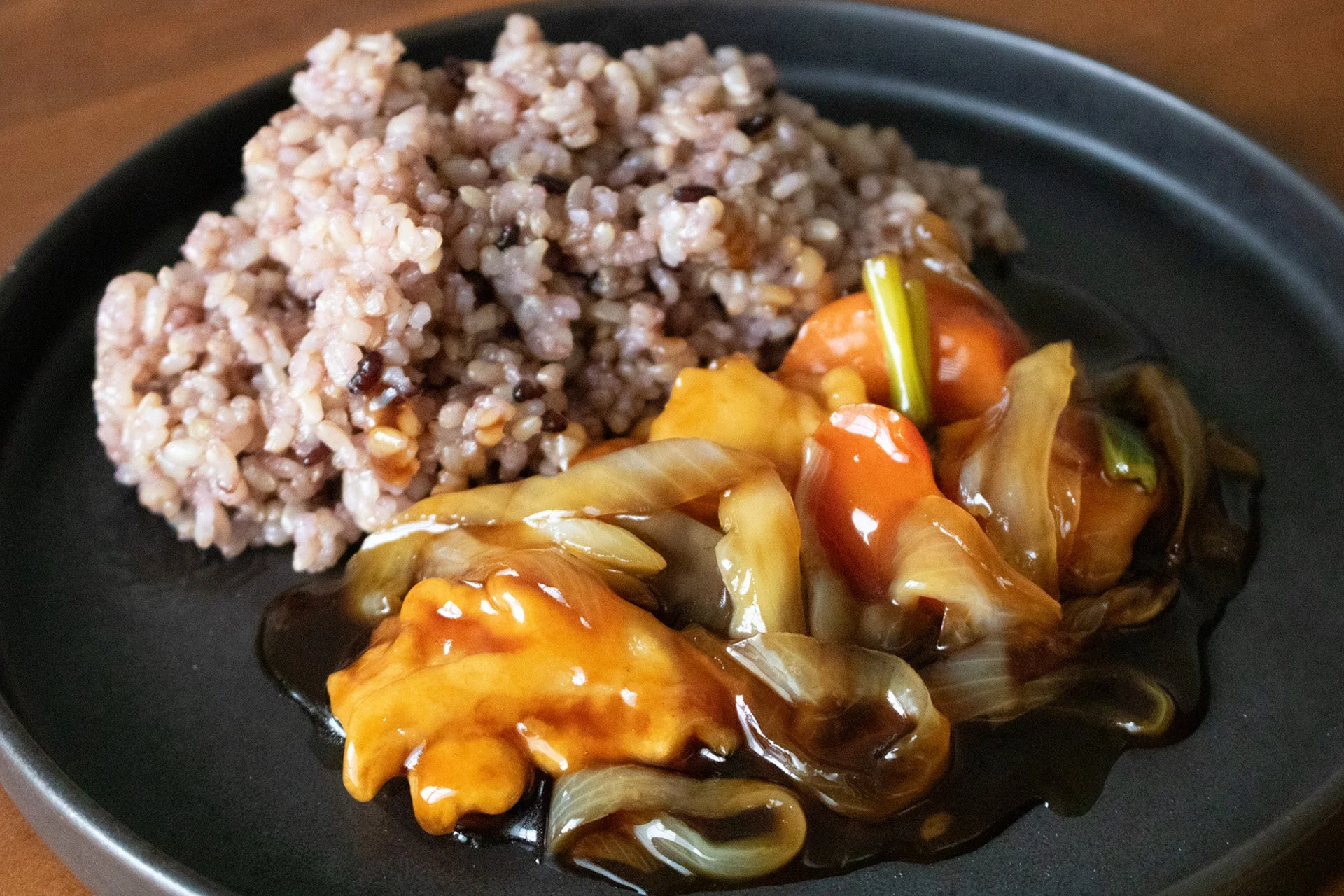 皿に盛り付けられた「寝かせ玄米®と白身魚の黒酢あん」