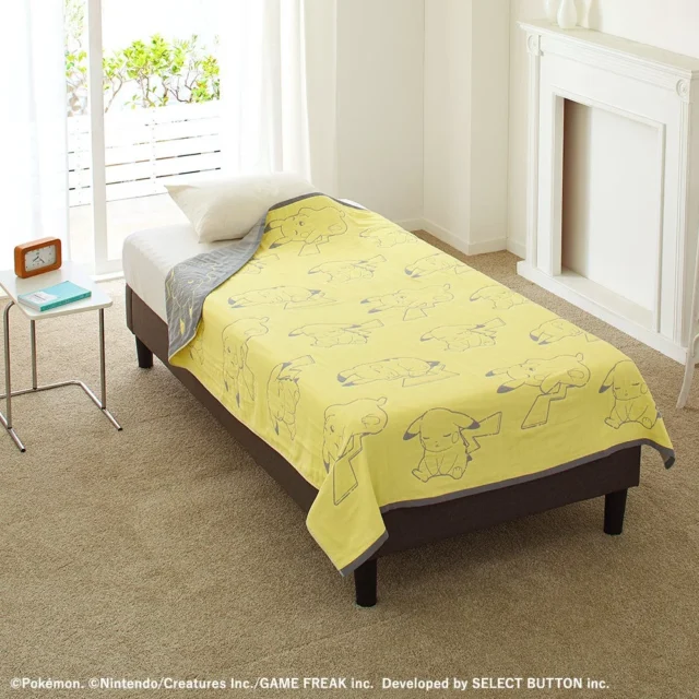 ベッドに広げられたピカチュウ柄の黄色い４重織ガーゼケット。