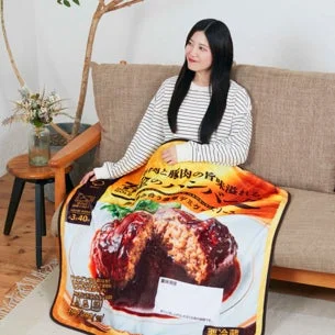 女性が金のハンバーグブランケットを羽織る様子