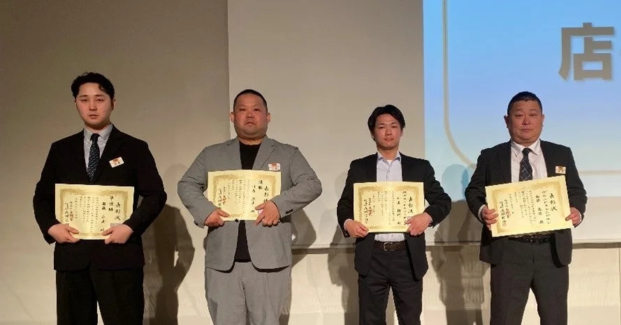 吉野家チャンピオン大会の優勝者と準優勝者が賞状を手に並ぶ表彰式の様子