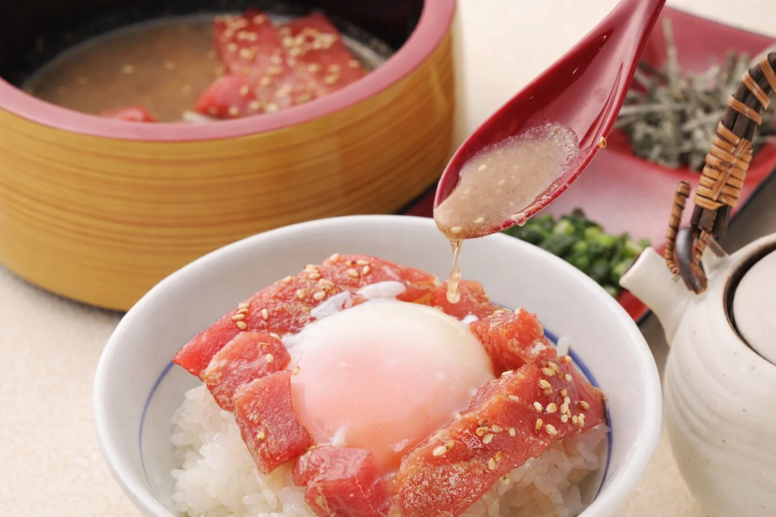 勝浦生まぐろ漁師めしにごま醤油だれをかける様子