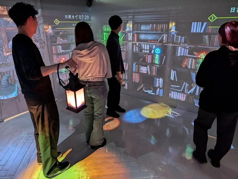 没入型アトラクション「CUBE」でランタンを手に館を探索するプレイヤーたち。