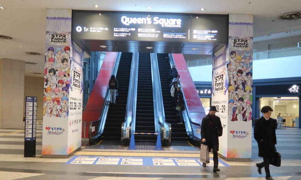 クイーンズスクエア横浜のエスカレーター横に設置されたSTPR Familyの大型広告