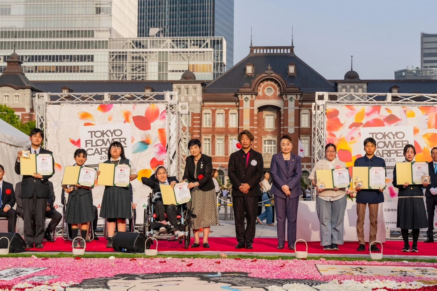 東京インフィオラータ2025の表彰式で花絵を囲む参加者たち