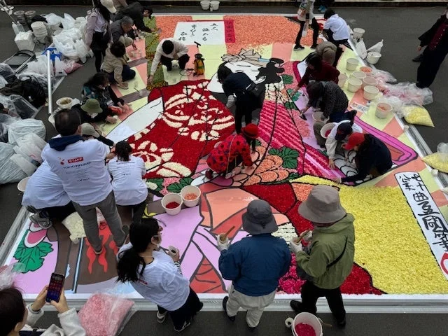 市民が協力して花絵を制作する様子
