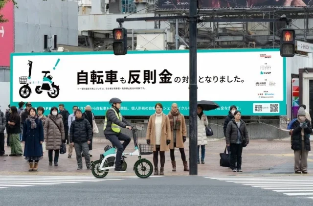 渋谷の街頭でLUUP電動アシスト自転車の模範走行を行うスタッフ