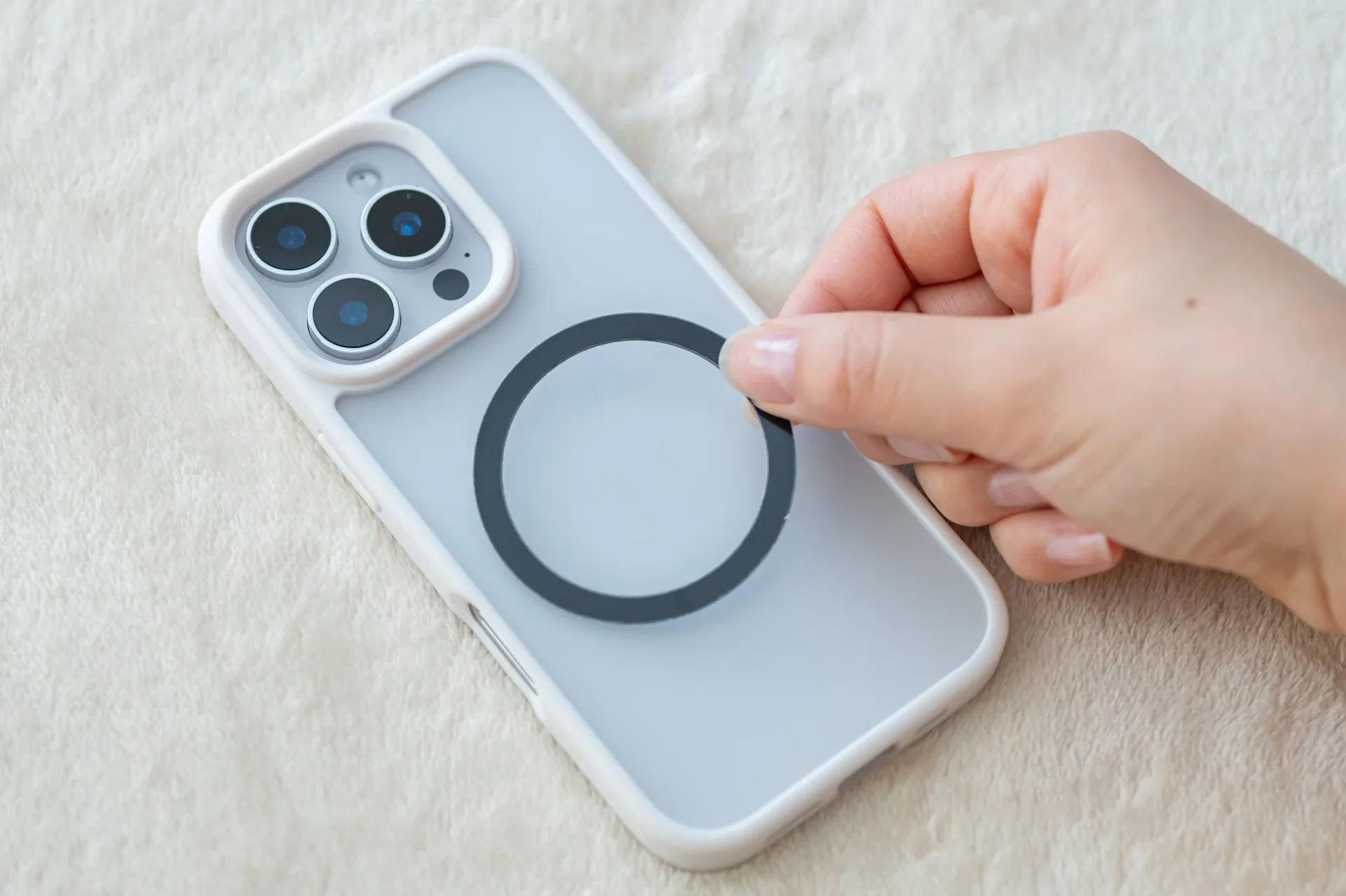 MagSafe非対応スマートフォンにスチールリングを貼り付ける様子