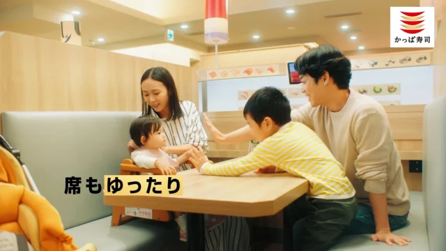 家族がゆったりとした席で食事を楽しむCMシーン。