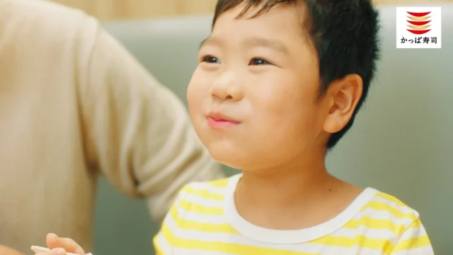 笑顔で満足げな子供の顔のCMシーン。