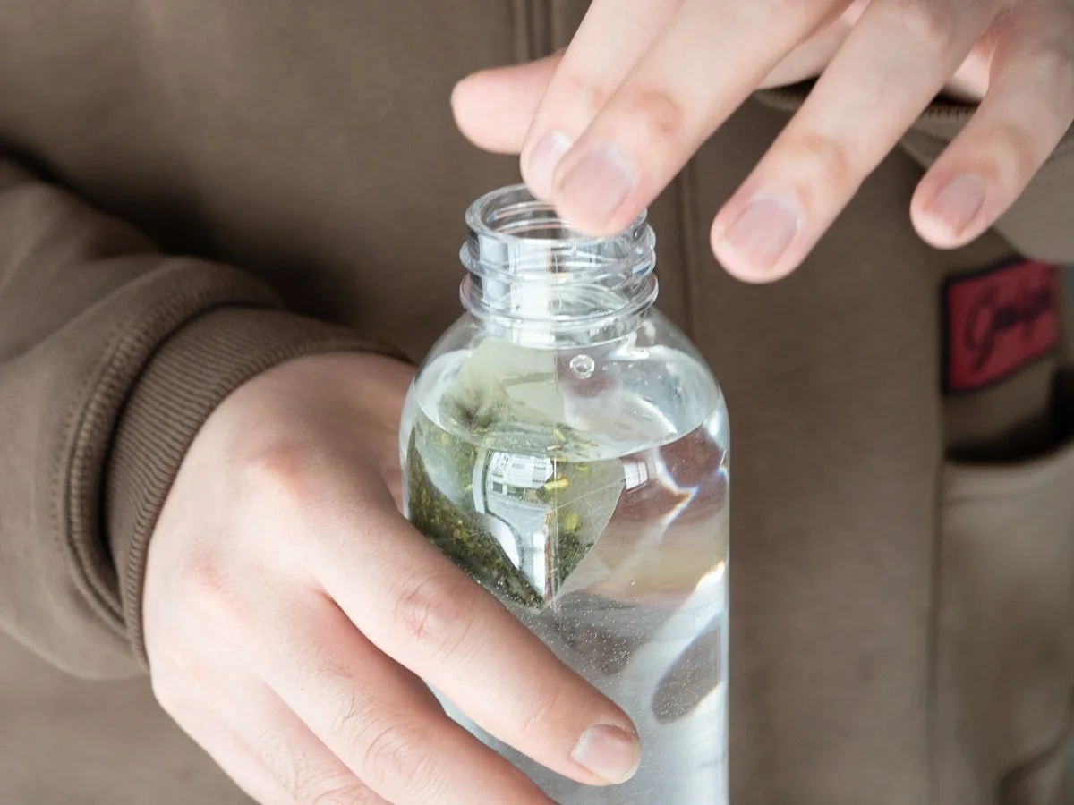 マイボトルに水出しティーバッグと水を注ぐ様子