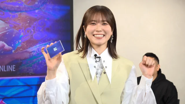 丹生明里さんが「特殊ハンデボックス」のカードを引いて笑顔を見せる