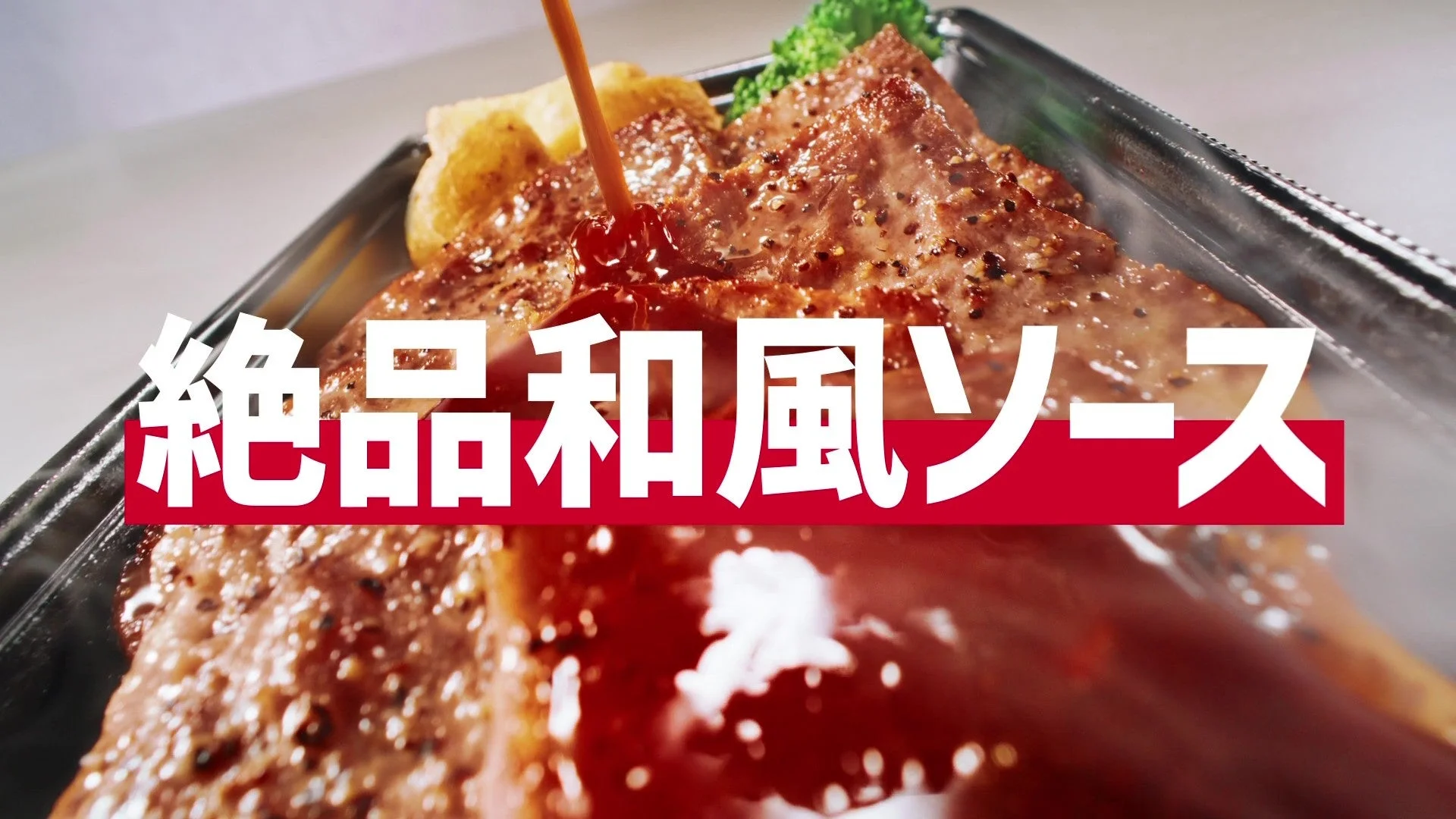 ほっともっと「新・ビーフカットステーキ重」に絶品和風ソースがかかる様子