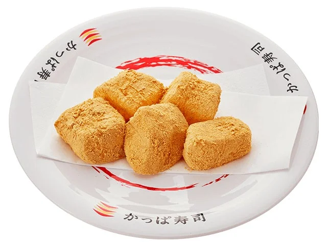 かっぱ寿司の「京わらび餅」。きな粉がまぶされたわらび餅が白い皿に乗っている。