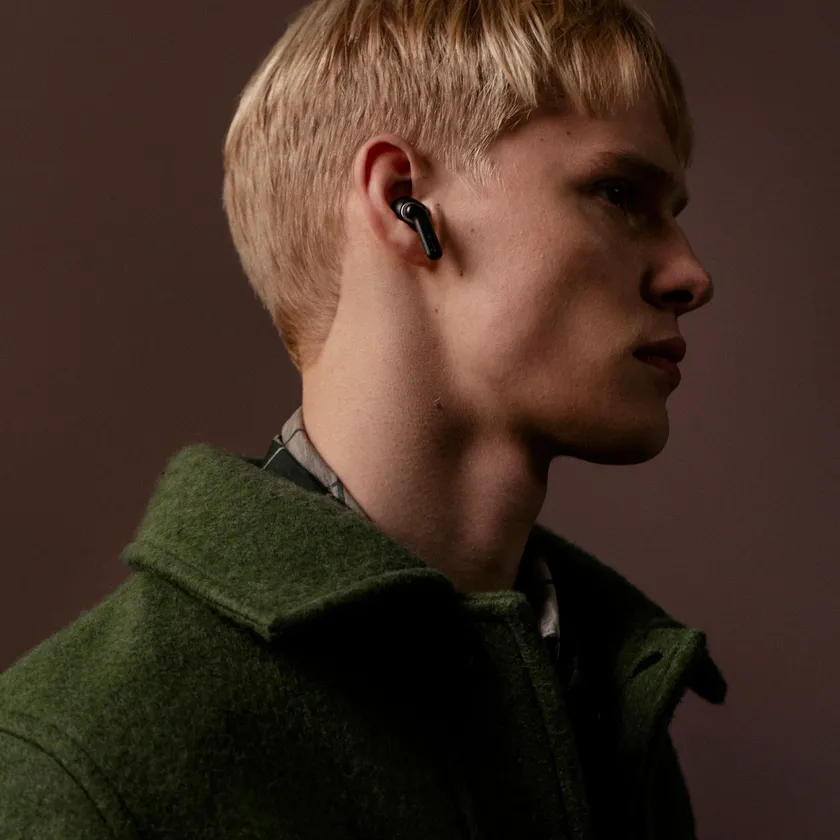 Sudio E4 Pro ミッドナイトブラックイヤホンを着用した男性