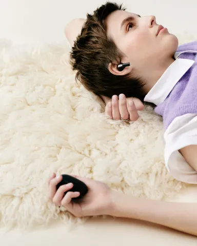 Sudio E4 Pro ミッドナイトブラックイヤホンを着用し横たわる女性