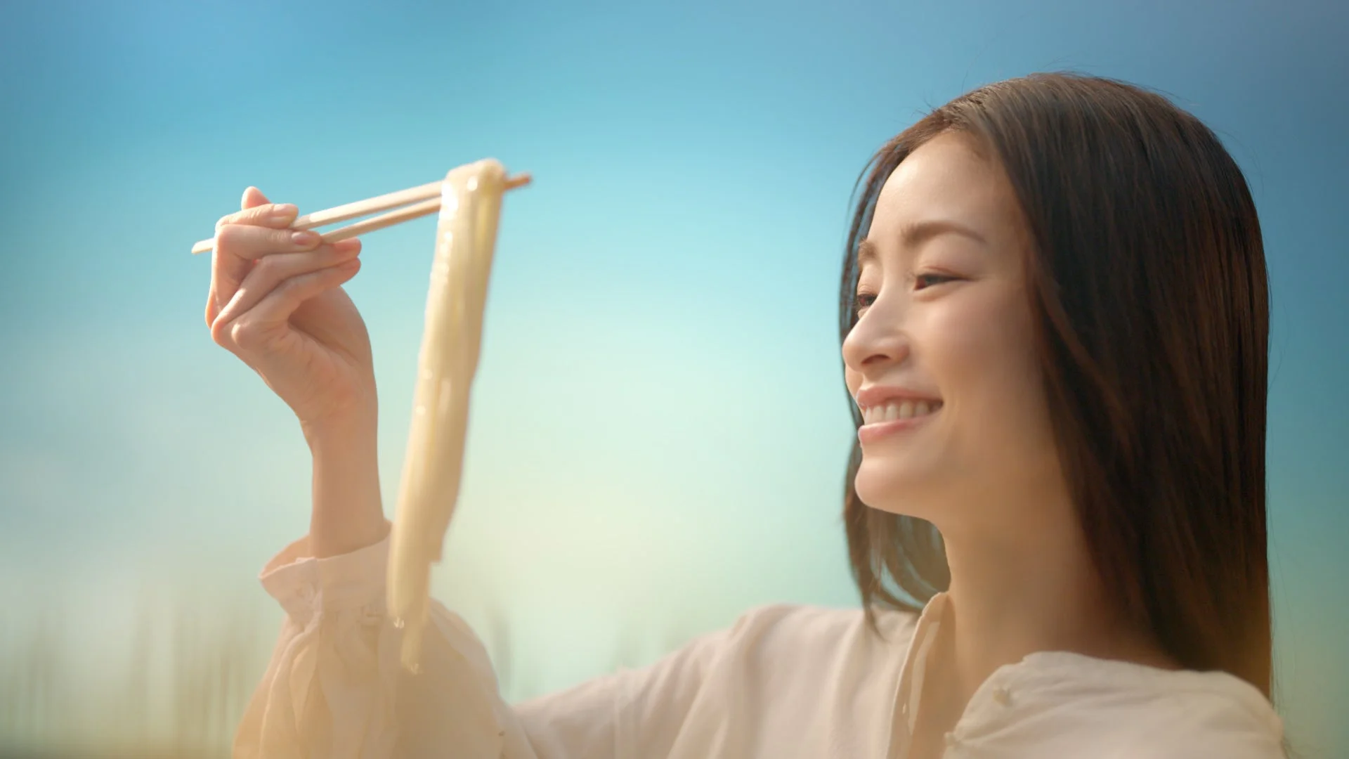 上戸彩さんが茹でたてのうどんを笑顔で持ち上げる