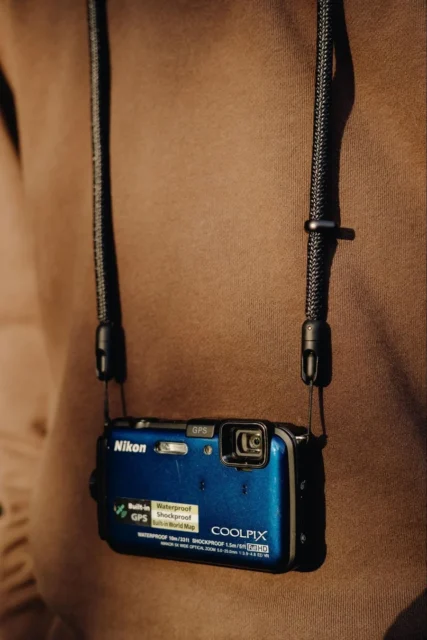 モバイル クロスボディ ストラップでNikon COOLPIXカメラを首から提げる様子