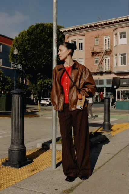 モバイル クロスボディ ストラップを装着して街中に立つ女性の全身